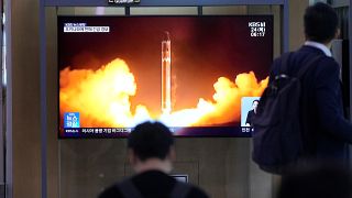 Dél-koreai járókelők nézik egy északi rakétakilövés képeit