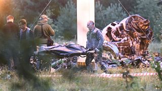 Egy ember holttestét viszik el a repülőgép becsapódásának helyszínéről