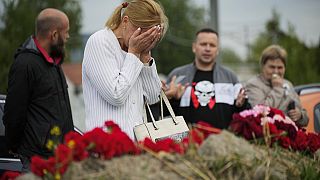 Женщина плачет у стихийного мемориала рядом с бывшим "Центром ЧВК "Вагнер" в Санкт-Петербурге