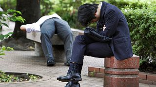 Parkban alvó üzletemberek Japánban - képünk illusztráció