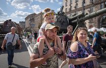 People look at a large column of burnt out and captured Russian tanks on display in Kyiv as Ukrainians mark Independence Day.