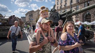 People look at a large column of burnt out and captured Russian tanks on display in Kyiv as Ukrainians mark Independence Day.