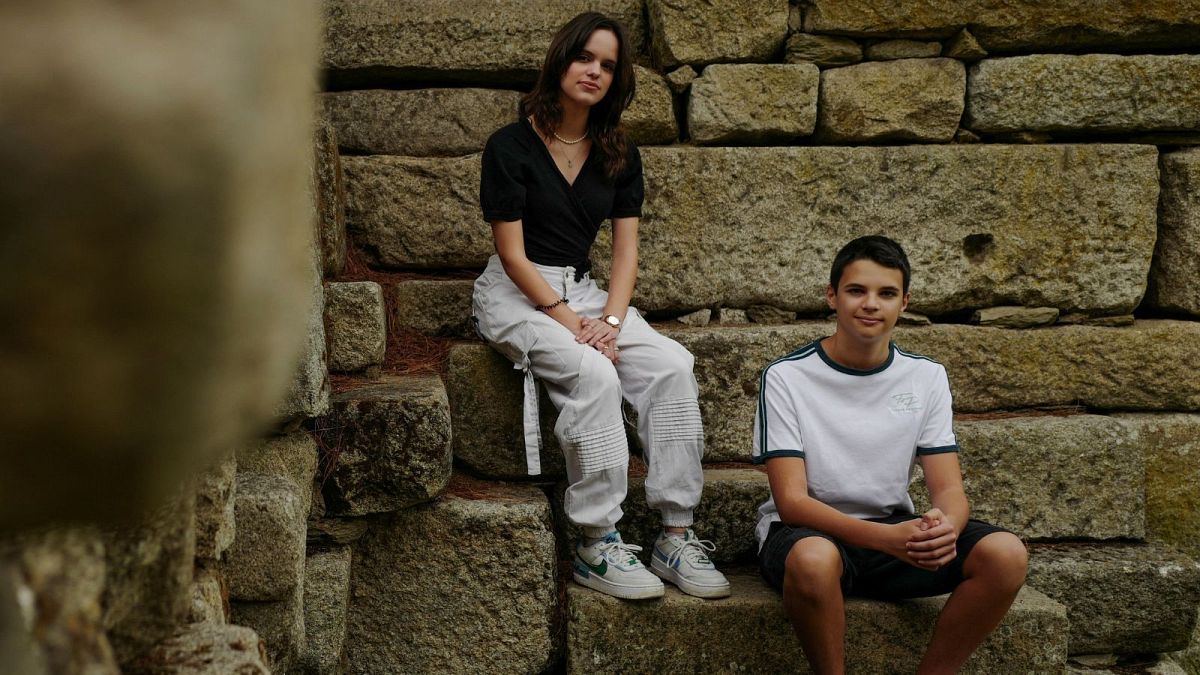 Andre, 15 and Sofia Oliveira, 18 pose for a picture in Almada, Portugal, 29 July 2023.