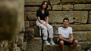 Andre, 15 and Sofia Oliveira, 18 pose for a picture in Almada, Portugal, 29 July 2023.
