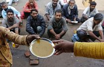 İnsanlar Hindistan'ın Ahmedabad kentinde bir lokantanın önünde ücretsiz yemek için bekliyor. 