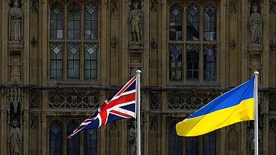 A Union Jack flag and a Ukraine flag fly in front of the Houses of Parliament on Ukraine Independence Day in London, Wednesday, Aug. 24, 2022.