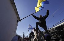 ΑΡΧΕΙΟ - Ένας άνδρας αφαιρεί μια ουκρανική σημαία μετά την κατάληψη της βάσης στη Novofedorivka της Κριμαίας, Σάββατο 22 Μαρτίου 2014.