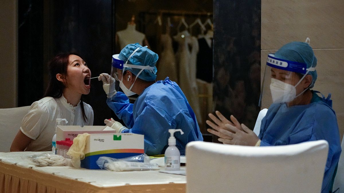 Çin'in başkenti Pekin'de bir foruma katılacak olan vatandaşlar, etkinlik öncesi koronavirüs testinden geçirilirken