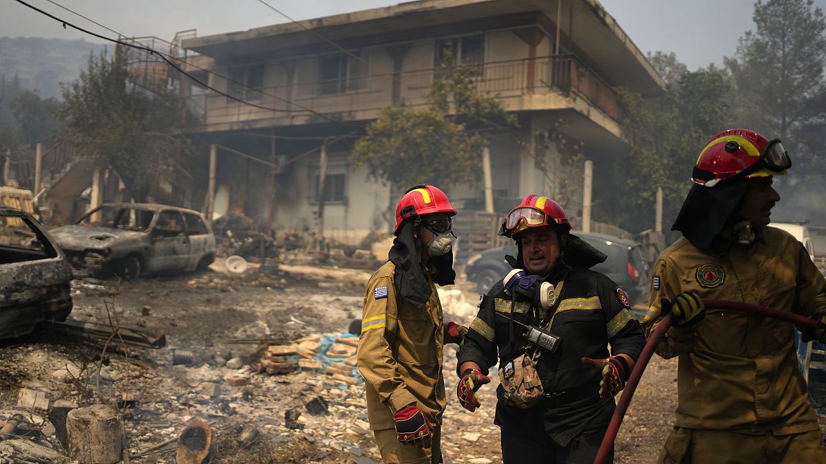 Tűzoltók egy leégett ház előtt Athén északi külvárosában 2023. augusztus 23-án