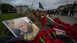 Sevenleri, St. Petersburg'daki Wagner ofisi önüne gelerek, Yevgeniy Prigojin'in fotoğrafının önüne çiçekler bırakıyor