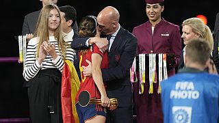President of Spain's soccer federation, Luis Rubiales, right, hugs Spain's Aitana Bonmati on the podium following Spain's win in the final of Women's World Cup.