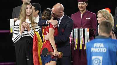 El Presidente de la Federación Española de Fútbol, Luis Rubiales, a la derecha, abraza a la española Aitana Bonmati en el podio tras la victoria de España en la final de la Copa del Mundo Femenina.