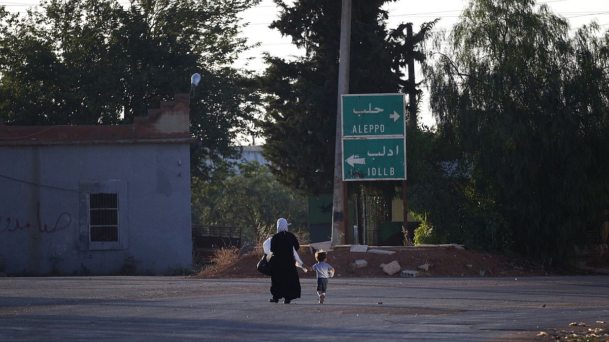 صورة أرشيفية. سيدة تمشي مع طفلها في إحدى بلدات ريف إدلب، شرق إدلب، سوريا، يونيو 2012