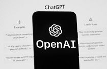 يظهر شعار OpenAI على هاتف محمول أمام شاشة الكمبيوتر التي تعرض شاشة ChatGPT الرئيسية، 17 مارس 2023، في بوسطن.