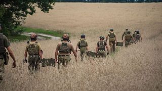 جنود أوكرانيون يحملون صناديق من الذخيرة