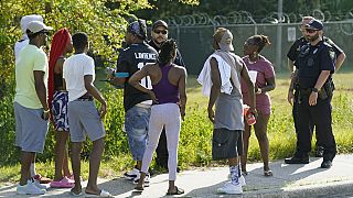 Residents talk with Jacksonville police officers near the scene of a mass shooting at a Dollar General store, Saturday, Aug. 26, 2023, in Jacksonville, Florida, US