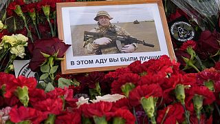 باقة من الزهور وعليها صورة لبريغوجين موضوعة أمام مقر شركة فاغنر في مدينة سان بطرسبرغ الروسية