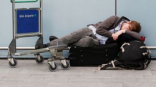Um viajante descansa com a sua bagagem enquanto os voos são atrasados e cancelados no aeroporto de Heathrow, em Londres, a 17 de maio de 2010