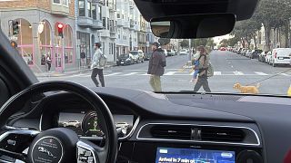Un taxi sin conductor de Waymo se detiene en un semáforo mientras los peatones cruzan la calle durante un viaje de prueba en San Francisco, el 15 de febrero de 2023.