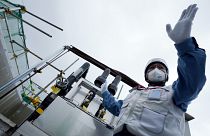 Сотрудник TEPCO проводит тур на объекте по очистке воды для журналистов