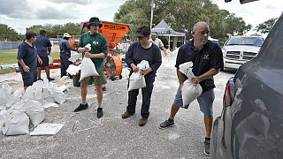 Miembros del Departamento de Parques y Recreación de Tampa, Florida, ayudan a los residentes a cargar sacos de arena el lunes 28 de agosto de 2023, en Tampa, Florida.