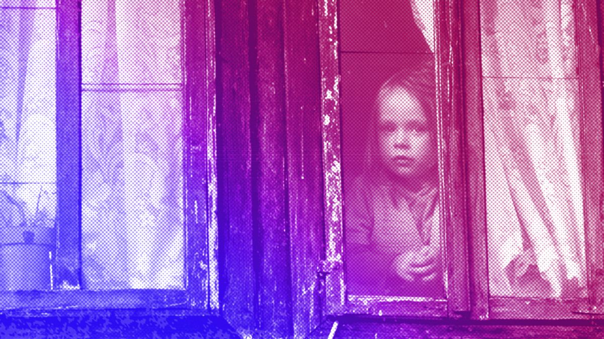 A girl peers from the window of her old family house near the Bosnian town of Kalesija, 2012