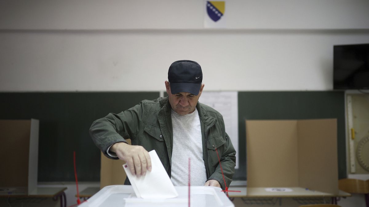 Un hombre bosnio deposita su voto en un colegio electoral de Sarajevo, Bosnia, el domingo 2 de octubre de 2022\. 