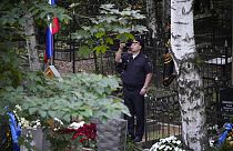 Rusya'daki Porokhovskoye mezarlığında düzenlenen cenaze töreninin ardından polis memuru, Wagner lideri Yevgeniy Prigojin'in mezarının fotoğrafını çekiyor,