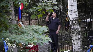 Sicherheitsbeame machen Fotos am Grab von Wagner-Chef Jewgeni Prigoschin