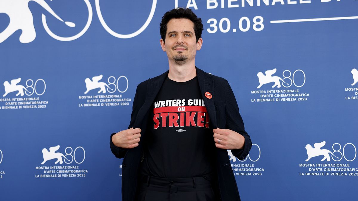 Le président du jury de la 80e Mostra de Venise, Damien Chazelle, porte un tee-shirt avec le slogan "Writers Guild on Strike", le mercredi 30 août 2023.