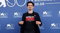 Le président du jury de la 80e Mostra de Venise, Damien Chazelle, porte un tee-shirt avec le slogan "Writers Guild on Strike", le mercredi 30 août 2023.