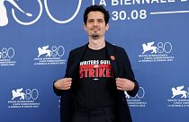 Le président du jury de la 80e Mostra de Venise, Damien Chazelle, porte un tee-shirt avec le slogan "Writers Guild on Strike", le mercredi 30 août 2023.