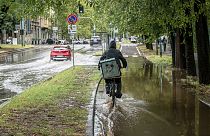 Un ciclista recorre una calle inundada en la zona de Sempione de Milán, Italia, el lunes 28 de agosto de 2023.