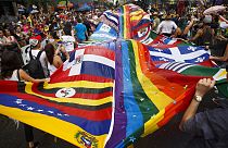 المحتفلون يرقصون مع أعلام الدول اللاتينية مقسمة بعلم الفخر خلال موكب تورونتو برايد في تورونتو، 24 يونيو، 2018.