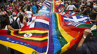 المحتفلون يرقصون مع أعلام الدول اللاتينية مقسمة بعلم الفخر خلال موكب تورونتو برايد في تورونتو، 24 يونيو، 2018.