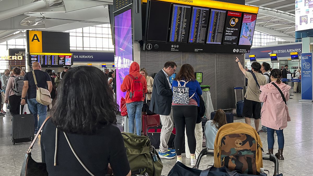 Pasajeros miran el tablón de salidas del aeropuerto de Heathrow, en Londres, el lunes 28 de agosto de 2023\. 