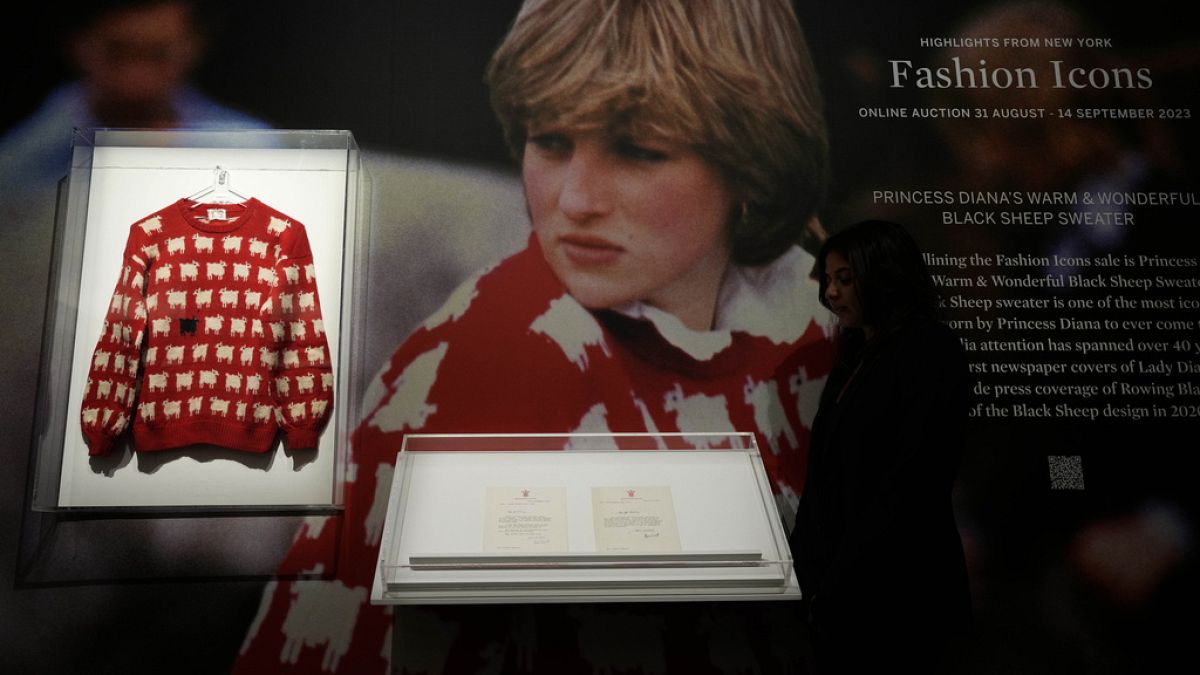 A Sotheby's employee looks at the historic Princess Diana black sheep jumper at the auction house Sotheby's in London, Monday, July 17, 2023. 