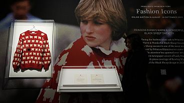 A Sotheby's employee looks at the historic Princess Diana black sheep jumper at the auction house Sotheby's in London, Monday, July 17, 2023. 