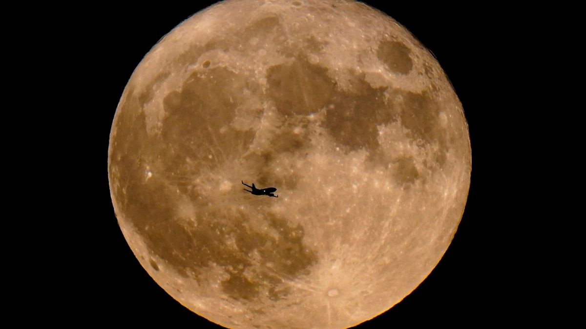 ARCHIVO - Un avión pasa por delante de una superluna, 13 de julio de 2022