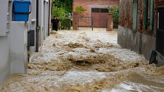 A man walks in a flooded street in the village of Castel Bolognese, Italy, Wednesday, May 17, 2023.