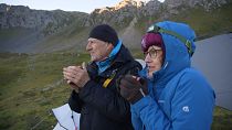 Aliki Buhayer-Mach (right) and her husband, François Mach-Buhayer (left) drink coffee after a night guarding sheep in the Swiss Alps.