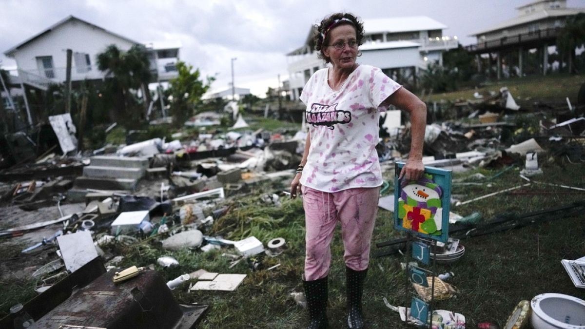 Jewell Baggett searches for anything salvageable from the trailer home in n Horseshoe Beach, Florida.