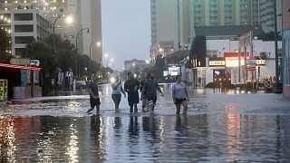 Οι άνθρωποι περπατούν σε μια πλημμυρισμένη λεωφόρο Ocean στο North Myrtle Beach, S.C. την Τετάρτη, 30 Αυγούστου 2023 μετά το πέρασμα του τυφώνα Idalia.