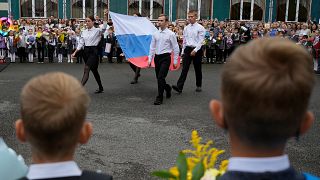 Os alunos carregam a bandeira russa durante uma cerimónia que marca o início das aulas " em St. Petersburg, Rússia, 1 de setembro de 2023