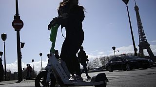 A woman rides a scooter in Paris, Friday, march 31, 2023.