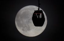 Des personnes observent la Super Lune Bleue à bord d'un téléphérique à Greenwich, à Londres, le mercredi 30 août 2023.