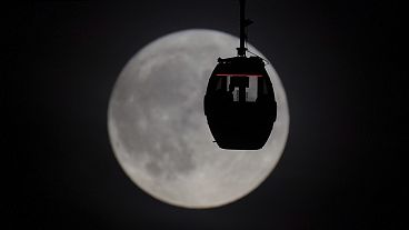 Des personnes observent la Super Lune Bleue à bord d'un téléphérique à Greenwich, à Londres, le mercredi 30 août 2023.