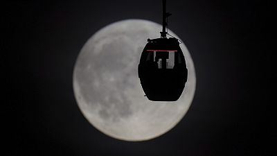 People view the Super Blue Moon as they travel in a Cloud Cable Car, in Greenwich, London, Wednesday, August 30, 2023