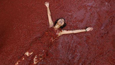 A reveller covered in tomato pulp takes part in the "Tomatina" annual food battle