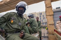 Agentes de policía nigerinos sentados frente a las oficinas de aduanas en Niamey, Níger, lunes 21 de agosto de 2023.